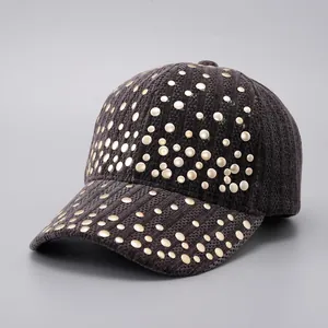 Detailed view of dark grey baseball cap featuring golden stud rivets and ribbed texture