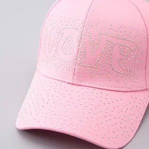 Dettaglio ravvicinato del motivo LOVE in strass scintillanti sul cappello rosa
