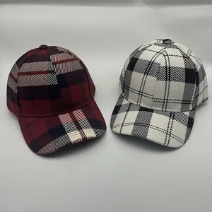 Dettaglio dei motivi a quadri stile inglese su due cappellini da baseball in cotone