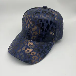 Detailed view of dark blue baseball cap with gold foil leopard print and curved brim