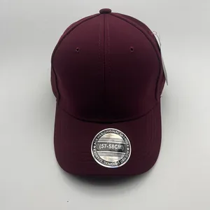 Detailed view of dark red baseball cap fabric with ventilation holes and silver sticker