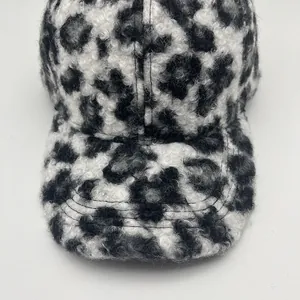 Detailopname van luipaardprint imitatie lamswol en stiksels op een winterse honkbalpet