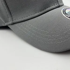 Detail shot of breathable grey mesh fabric and curved stitching on the baseball cap