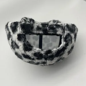 Detail van de zwart-wit fleece pet met luipaardprint en verstelbare klittenbandsluiting
