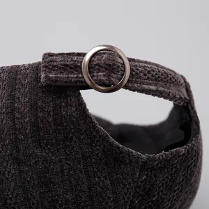 Detail of adjustable metal ring buckle and ribbed corduroy texture on baseball cap