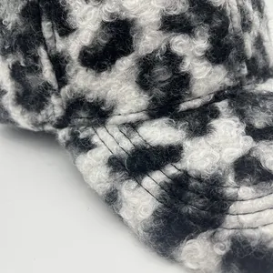 Detailopname van de pluizige baseballpet met zwart-witte luipaardprint en stiksel