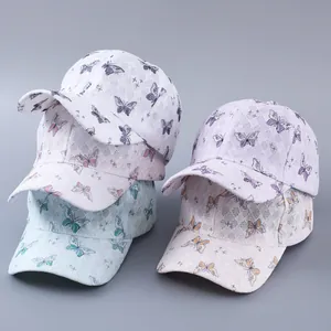 Close-up of lace baseball caps with colorful butterfly prints and sparkly rhinestone details
