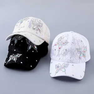 Detailsicht auf Baseballkappen mit zarter Spitze und Schmetterling aus Strasssteinen