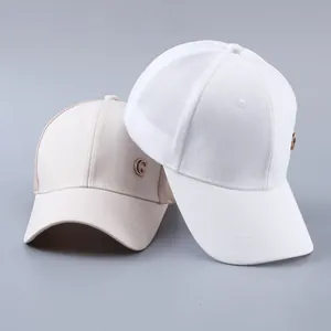 Close-up of white and beige mesh baseball caps with sparkling G-shaped metal emblem