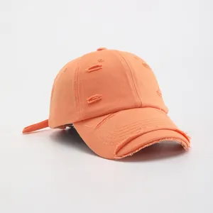 Distressed bright orange cotton baseball cap with ripped holes and vintage frayed edges