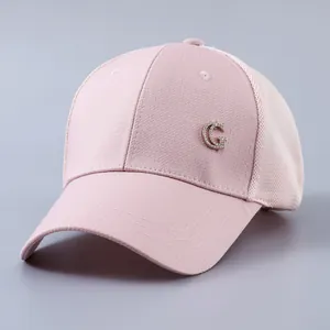 Detail of pink mesh baseball cap featuring a rhinestone-studded metal G badge