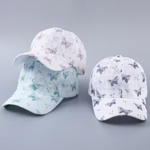 Detail of lace baseball caps with butterfly embroidery and rhinestone embellishments