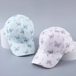 Detail of white lace baseball cap featuring blue and pink butterfly prints on a stand