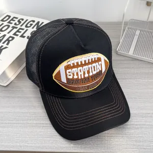 Dettaglio del cappellino trucker nero retrò con ricamo football americano e retro in rete