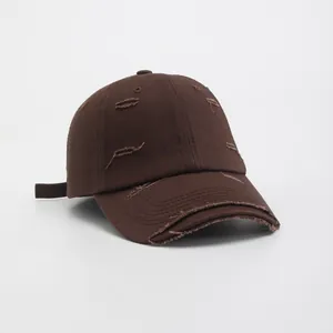 Detail view of dark brown twill cotton baseball cap with vintage distressed torn edges