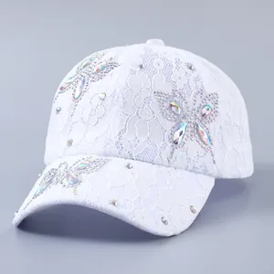Detail der weißen Spitzen-Baseballkappe mit glitzernden Strass-Schmetterling-Verzierungen