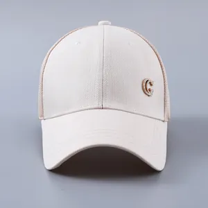Macro shot of a beige mesh baseball cap featuring a diamond-studded metal G logo