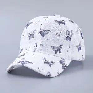 Detail of white lace baseball cap featuring purple butterfly patterns and embroidery