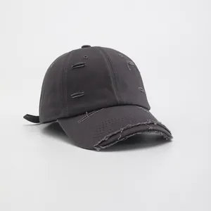 Detail of distressed dark grey baseball cap showing vintage frayed edges and cotton texture