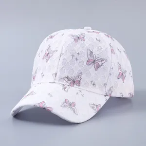 Close-up of white lace baseball cap with pink butterfly print and sparkling rhinestones