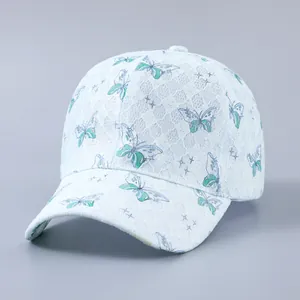 Close-up of light blue baseball cap with white lace overlay and butterfly patterns