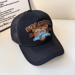 Dettaglio del cappellino trucker nero con ricamo dettagliato di orso bruno e stazione