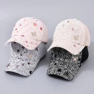 Dettaglio cappellini in tweed e mesh con fiori di paillettes e decorazione a farfalla