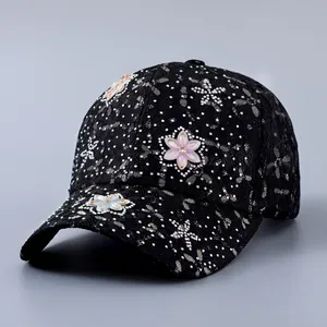 Detail einer schwarzen Spitzen-Baseballkappe mit 3D-Blumen und glänzenden Strasssteinen