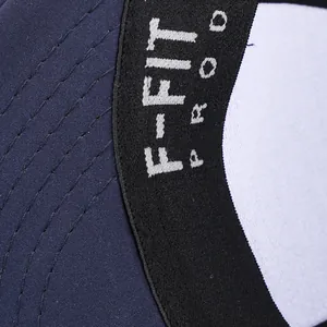 Dettaglio macro del cappello hip-hop blu navy con cuciture rinforzate e testo F-FIT PROD