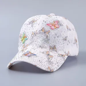 Close-up of white lace baseball cap featuring 3D butterfly patches and sparkling rhinestones