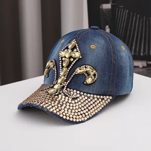 Detailed view of luxury rhinestone fleur-de-lis pattern on a navy denim baseball cap