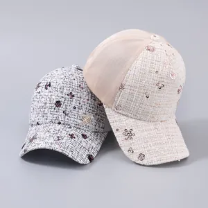 Dettaglio di cappellini in tweed con fiori di paillettes e retro in rete traspirante