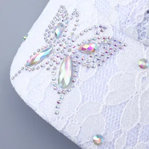 Makro-Detail aus weißer Spitze mit glitzerndem Strass-Schmetterling auf der Baseballkappe