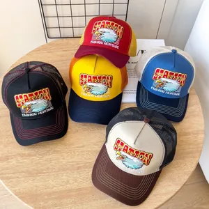 Dettaglio dei cappellini baseball vintage con ricamo di aquila su sfondo di legno