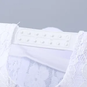 Detail der weißen Baseballkappe aus floraler Spitze mit verstellbarem Kunststoff-Druckknopfverschluss