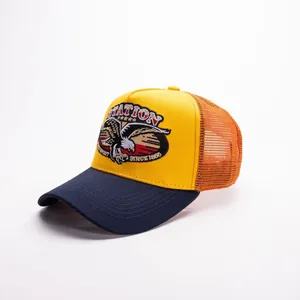 Dettaglio del cappello trucker con toppa aquila e rete arancione traspirante sul retro