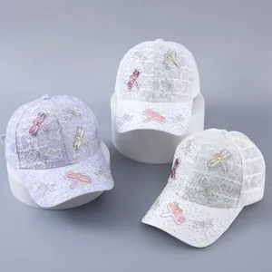 Detail of lace baseball cap with rhinestone dragonflies and butterfly patches