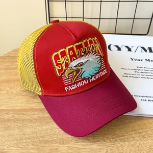 Dettaglio del cappellino trucker vintage con ricamo aquila e contrasto rosso giallo