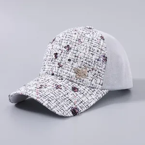 Dettaglio cappellino in tweed con paillettes e spilla a farfalla in metallo con strass