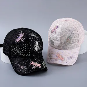 Detail of lace baseball cap with rhinestone dragonfly ornaments in black and pink