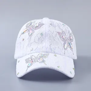 Detailansicht der weißen Spitze und der bunten Strass-Schmetterlinge auf der Baseballkappe