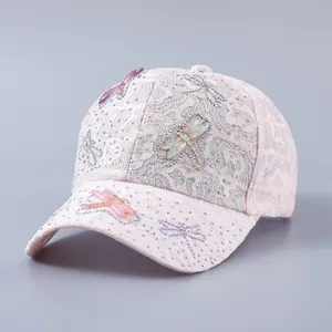 Detailed side view of pink lace baseball cap with dragonfly and rhinestone embellishments