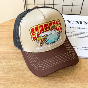 Dettaglio della toppa ricamata con aquila su un cappello trucker vintage con rete