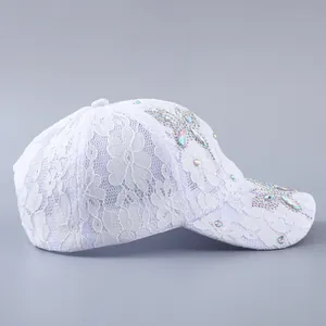 Detailaufnahme von weißem Blumen-Spitzenstoff und Schmetterlingsmuster aus AB-Kristallen