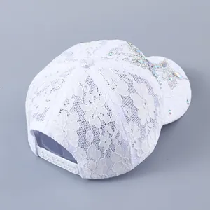 Detail der weißen Baseballkappe aus Spitze mit bunten Strass-Schmetterlingen und Snapback