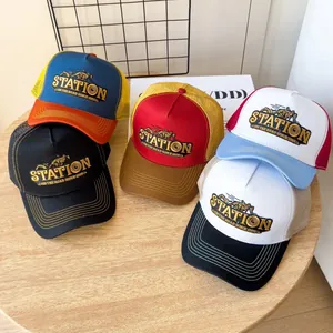 Dettaglio di cappelli trucker vintage con rete e ricamo STATION su un tavolo di legno
