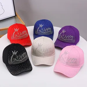 Variety of rhinestone Queen baseball caps in six colors on a stylish white display stand