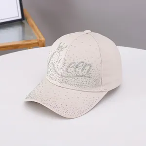 Beige baseball cap with Queen rhinestone lettering and crown icon in a stylish design