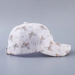 Detailed side view of white lace baseball cap with butterfly print and metal buckle