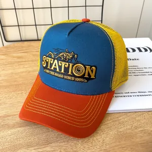 Dettaglio cappello trucker vintage con ricamo station e cuciture a contrasto su legno